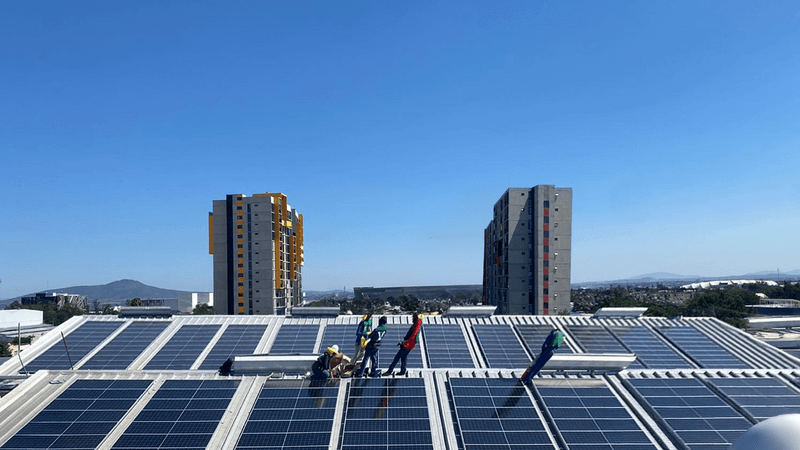 Casa con paneles solares con persona alcanzado el sol