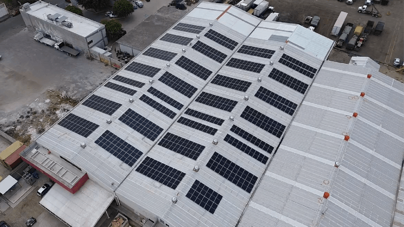 Casa con paneles solares con persona alcanzado el sol