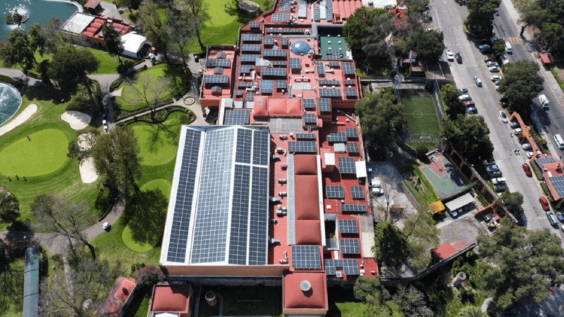 Casa con paneles solares con persona alcanzado el sol